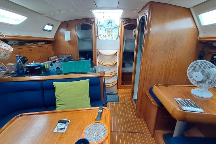 Interior of 2000 Jeanneau Sun Odyssey 37 sailboat with wooden furnishings and cozy seating.