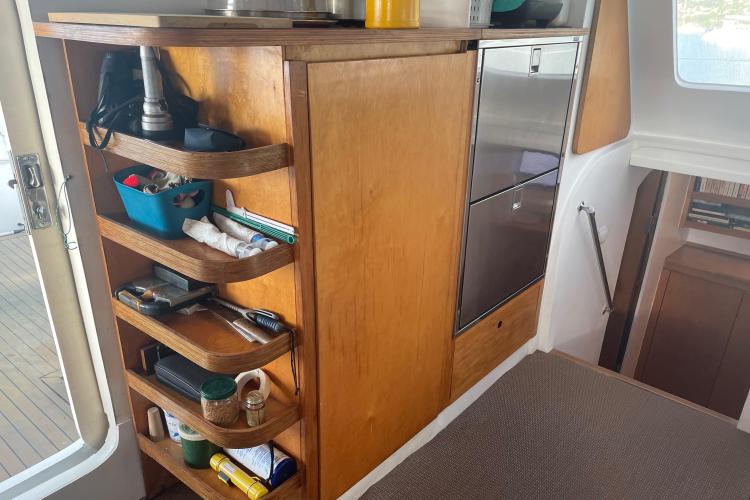 Wooden storage shelves with various items on a boat, Custom KSENIA 149, 2010 model.