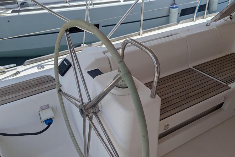 Steering wheel of 2017 Dufour 460 Grand Large yacht with wooden seating.