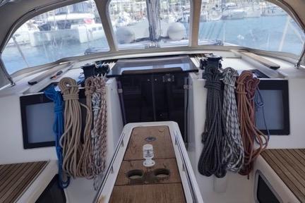 Cockpit of 2017 Dufour 460 Grand Large sailboat with ropes and wooden seating.