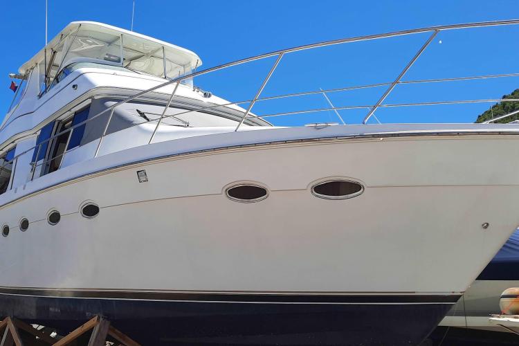 2000 Carver 530 Voyager Pilothouse yacht with sleek design against clear blue sky.