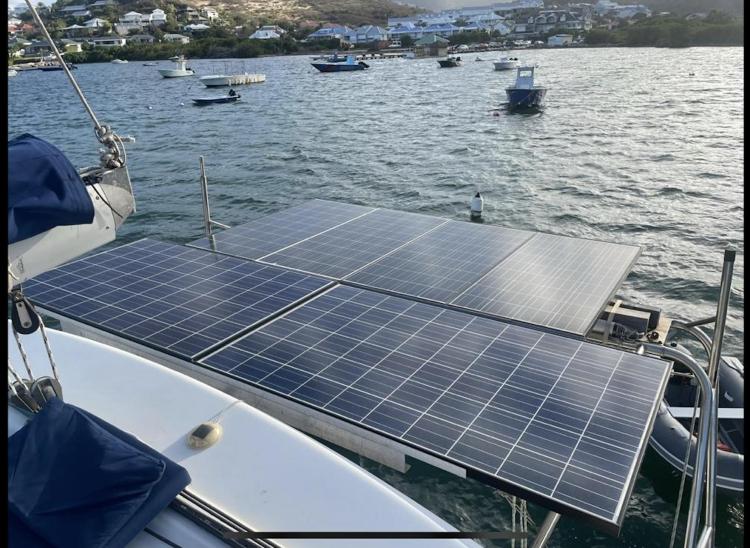 Solar panels on a 2009 Fountaine Pajot Orana 44 catamaran, docked in a scenic harbor.