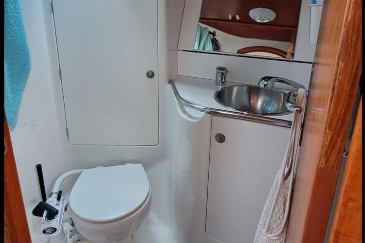 Compact bathroom in a 2000 Jeanneau Sun Odyssey 37 sailboat, featuring a toilet and sink.