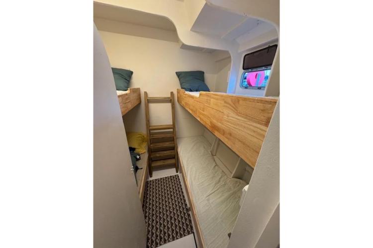 Bunk beds in 2004 Etoile Marine Maxi Cat 24 cabin, featuring wooden ladder and cozy interior.
