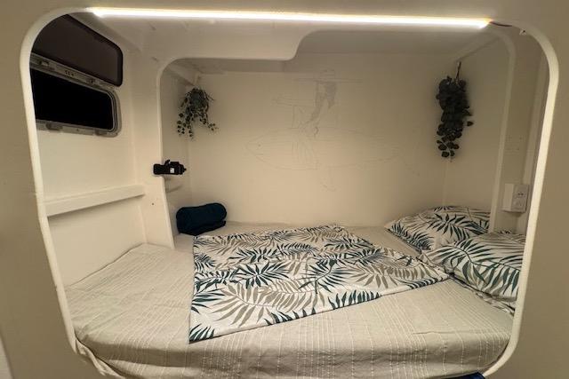 Cozy cabin interior of 2004 Etoile Marine Maxi Cat 24 with tropical bedding and soft lighting.