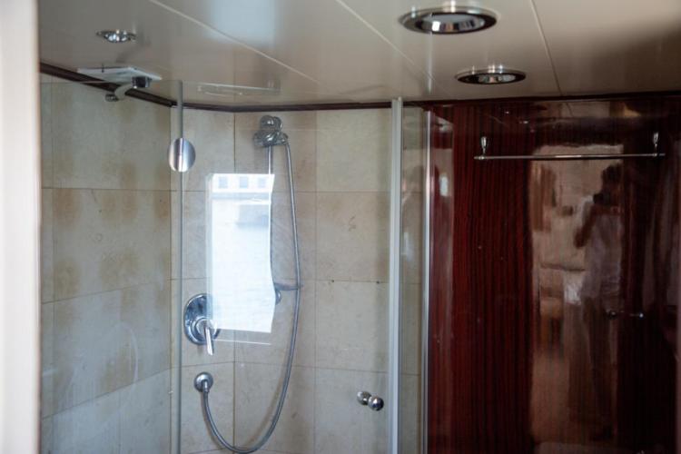 Shower area in a 1972 Benetti 33 yacht, featuring modern fixtures and wood paneling.