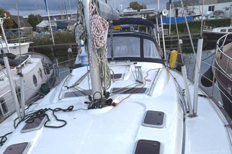 2006 Bavaria Cruiser 46 sailboat docked in a marina, featuring a clean deck and rigging.