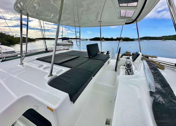 2023 Lagoon 46 catamaran with spacious deck, sleek design, and scenic waterfront view.