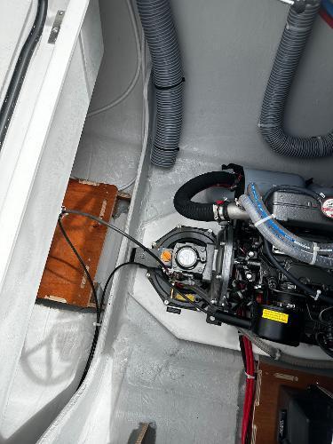 Engine compartment of a 2024 Excess 11 boat, showcasing mechanical components and wiring.