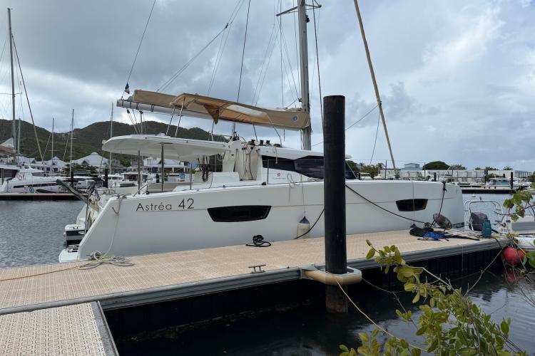 2020 Fountaine Pajot Astrea 42 catamaran docked at marina under cloudy sky.