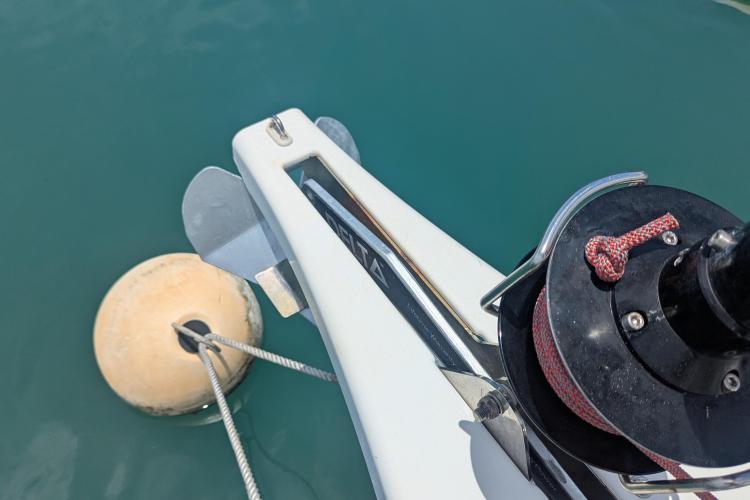 Bow of 2017 Dufour 460 Grand Large yacht with anchor and mooring buoy.