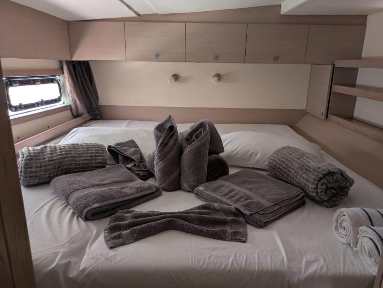 Luxurious Catana 55 yacht bedroom with neatly arranged towels, 2012 model.