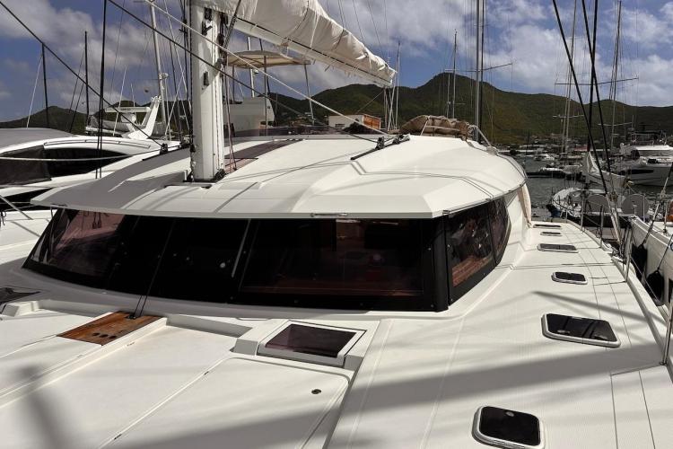 2016 Fountaine Pajot Ipanema 58 catamaran docked in a marina, surrounded by other boats.