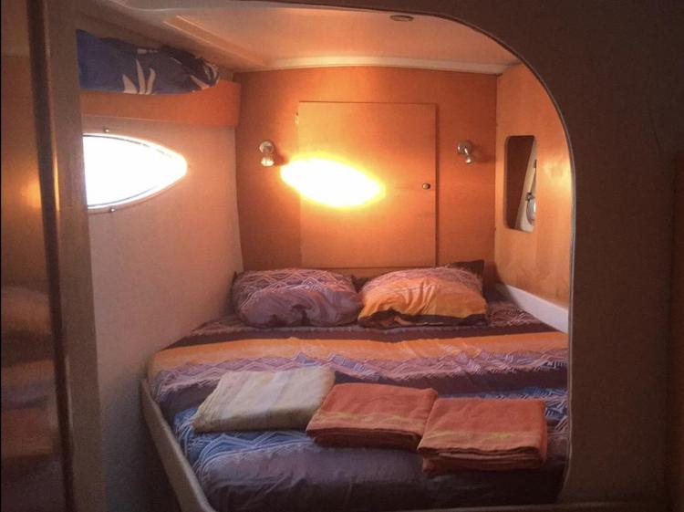 Cozy cabin interior of 2009 Fountaine Pajot Orana 44 catamaran with bed and porthole.