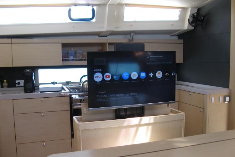 Modern interior of 2019 Beneteau Oceanis 46.1 yacht with TV and sleek kitchen design.