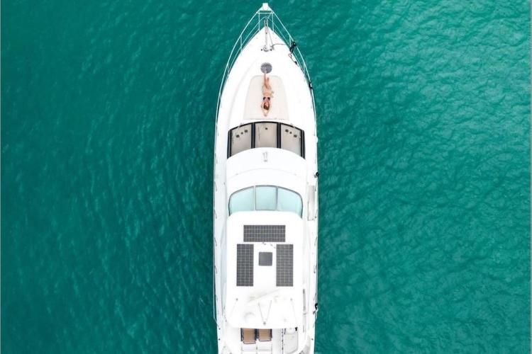 Aerial view of 2000 Carver 530 Voyager Pilothouse yacht on turquoise water.