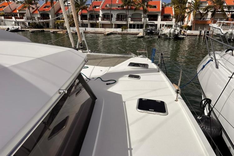 2016 Fountaine Pajot Ipanema 58 catamaran docked near waterfront homes.
