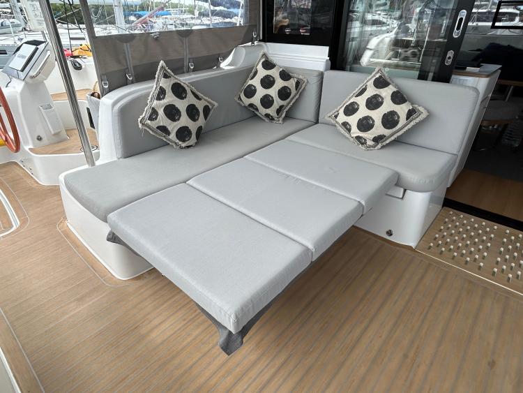 2024 Excess 14 yacht interior with gray seating and patterned cushions.
