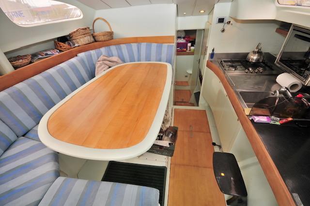 Interior of 2005 Custom Polynésie 42 yacht with cozy dining and kitchen area.