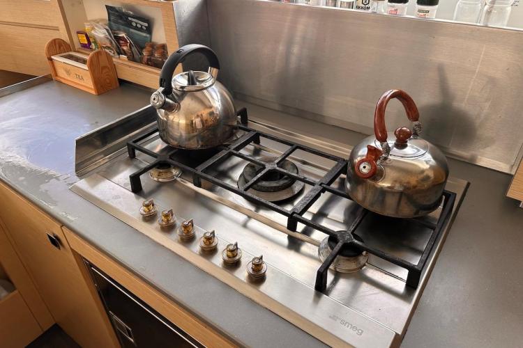 Stainless steel stovetop with kettles in a 2016 Fountaine Pajot Ipanema 58 yacht kitchen.
