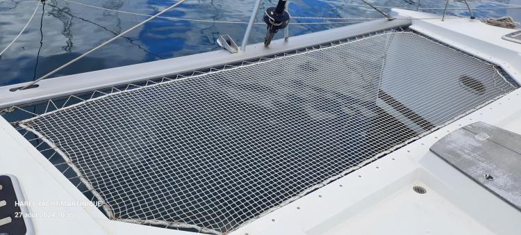 Trampoline net on 2017 Fountaine Pajot SABA 50 catamaran, reflecting blue sky and water.