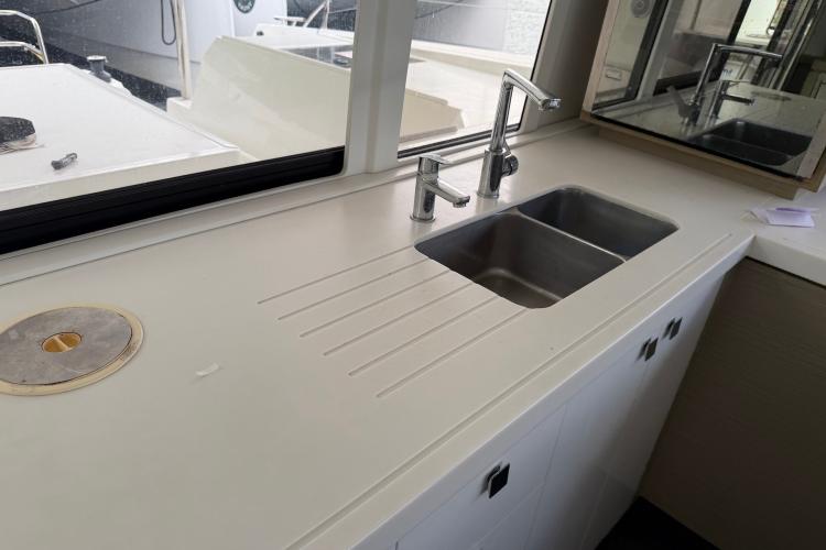 Modern kitchen sink on 2020 Fountaine Pajot Astrea 42 catamaran, featuring sleek design and dual faucets.