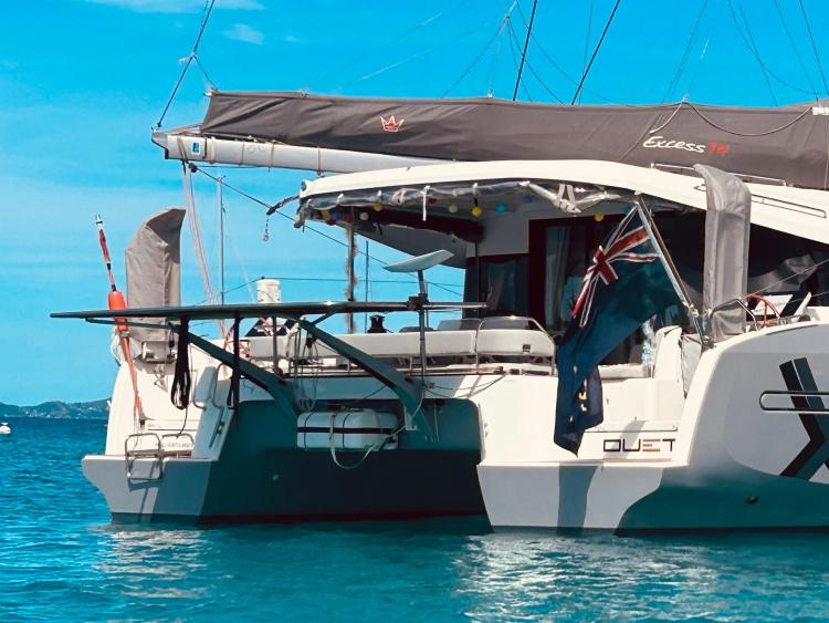 2024 Excess 14 catamaran anchored in clear blue waters, featuring sleek design and modern amenities.
