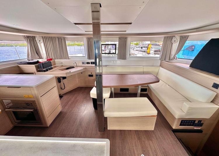 Interior of 2023 Lagoon 46 catamaran with modern kitchen and dining area.