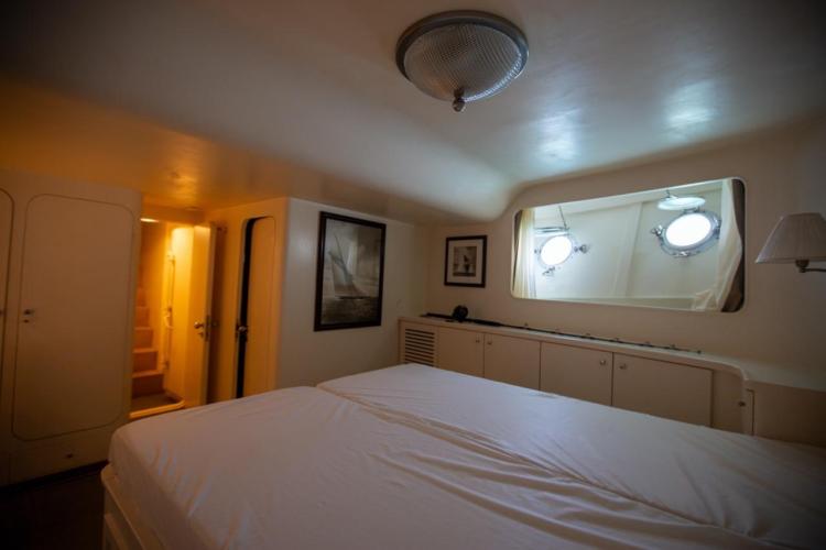 Interior of 1972 Benetti 33 yacht cabin with bed, portholes, and nautical decor.