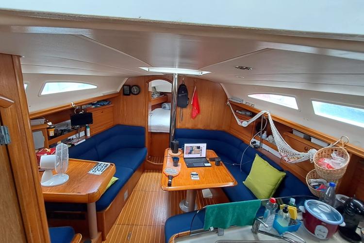 Interior of 2000 Jeanneau Sun Odyssey 37 sailboat with cozy seating and wooden finishes.