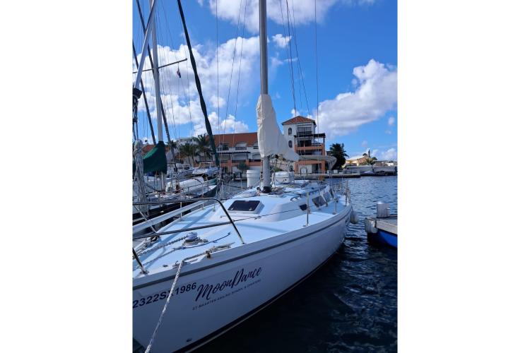 1986 Dufour CATALINA sailboat docked in marina under blue sky.