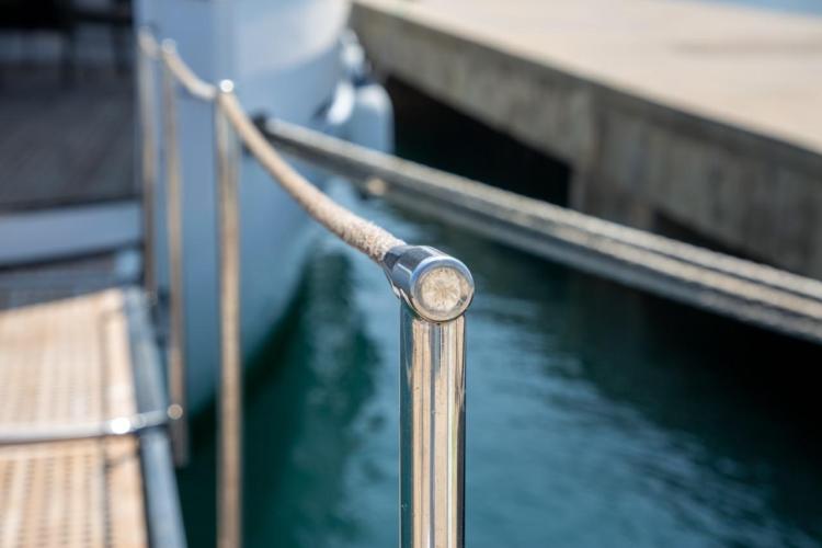Close-up of Benetti 33 yacht railing, 1972 model, docked by the water.
