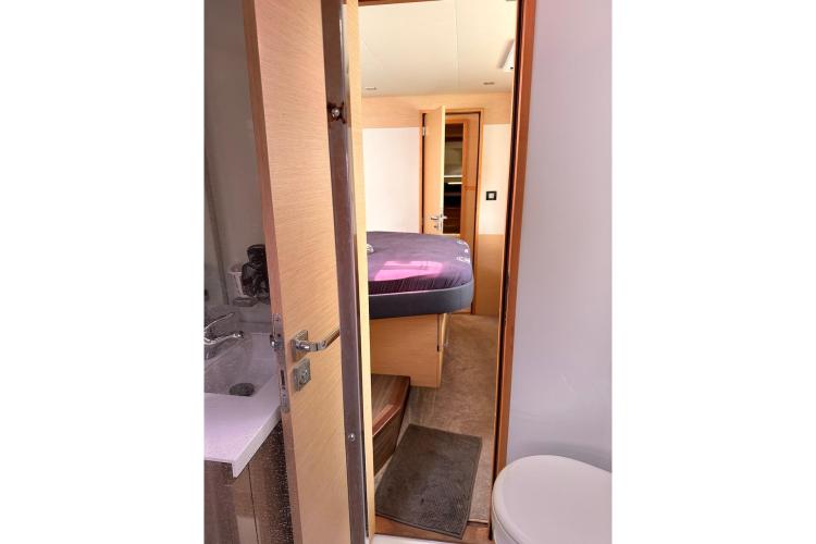 Interior cabin view of 2016 Fountaine Pajot Ipanema 58 yacht, featuring a cozy bedroom and bathroom.